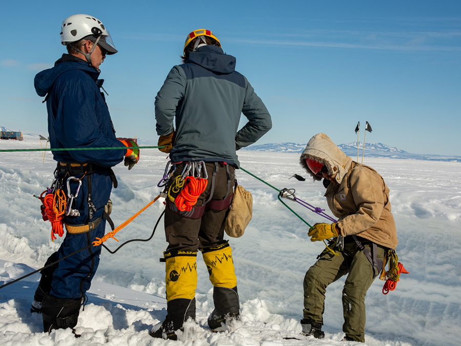 With John Loomis (left) assisting, Christina Bovinette guides Peter Pankowsky as he rappels down the crevasse simulator. 
